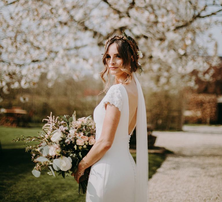 Bride in Pronovias Dralan Wedding Dress Standing in Front of White Blossom Tree