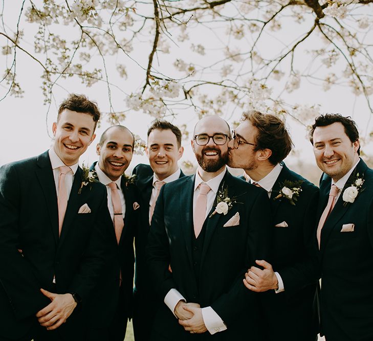 Groom and Groomsmen in Navy Moss Bros. Suitswith Pink Ties