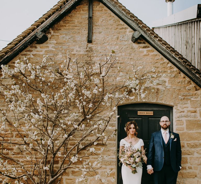 Bride in Pronovias Dralan Wedding Dress and Groom in Navy Moss Bros. Suit