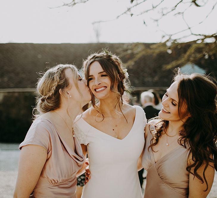 Bridesmaid in Pink Ghost Dress Giving Bride in Pronovias Dralan Wedding Dress a Kiss