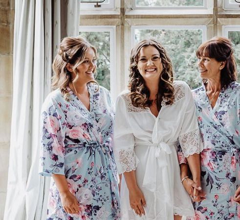 Bride and her bridesmaids getting ready wearing lace and floral kimonos for rustic wedding with pastel floral decor