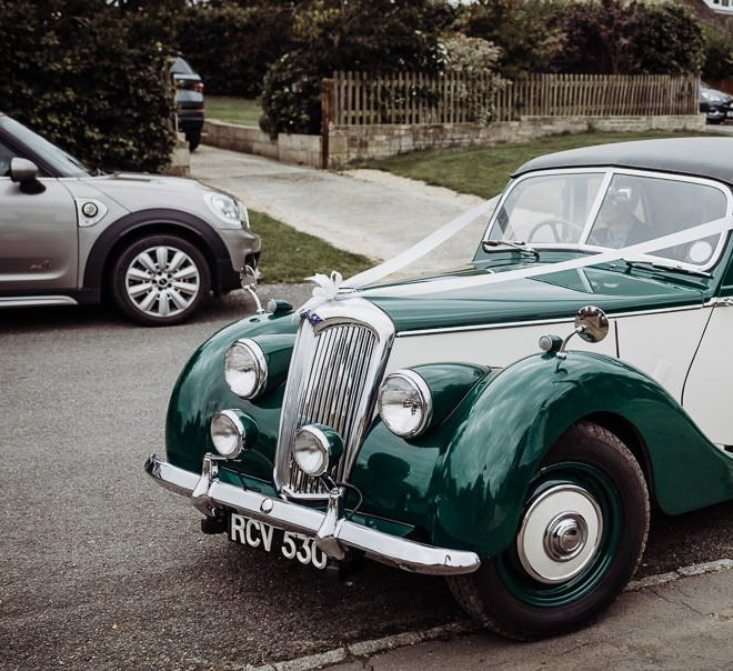 Vintage wedding car at Cogges Manor Farm celebration with rustic styling and floral decor