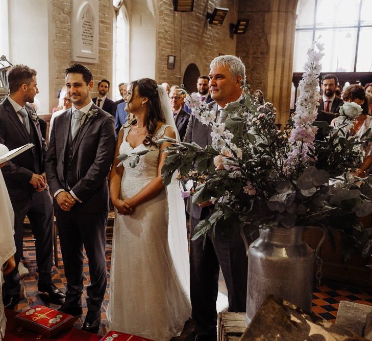 Bride and groom tie the knot at an intimate church wedding with pastel floral decoration before travelling to barn reception