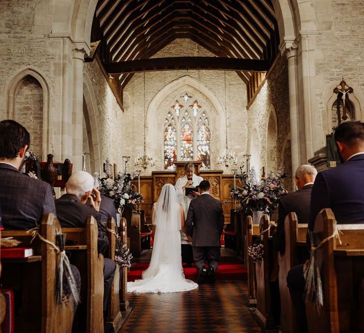 Bride and groom tie the knot at church ceremony with floral decor