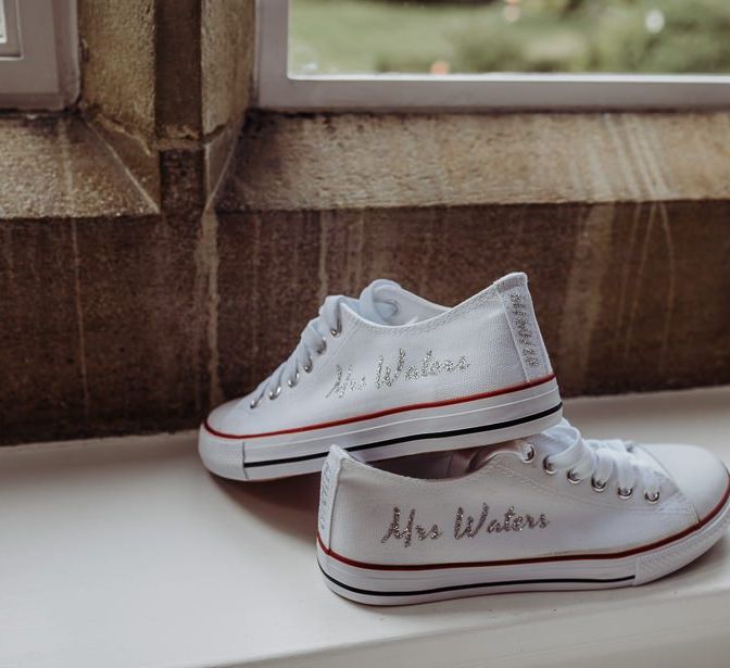 Personalised bridal trainers with embellished writing at rustic barn wedding in The Cotswolds