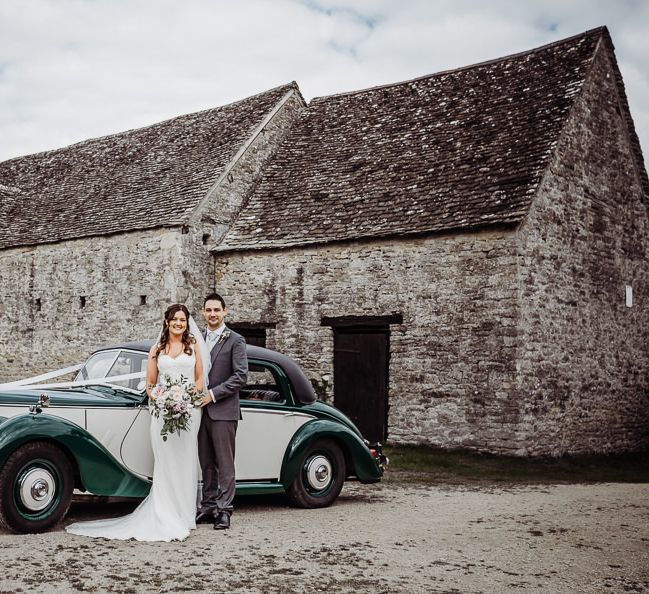 Bride and groom arrive in vintage wedding car to Cogges Manor Farm