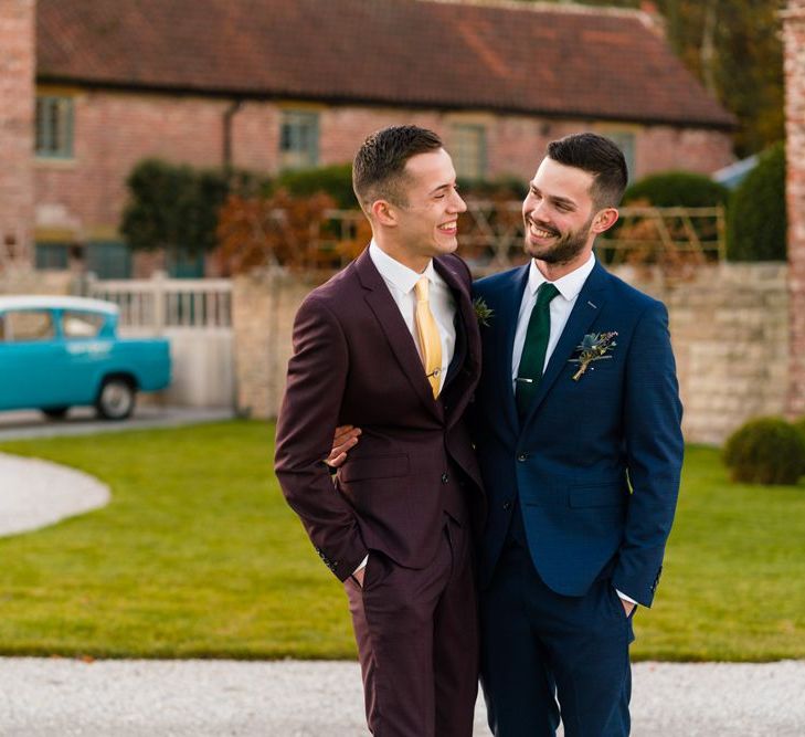 Grooms in Burgundy and Navy Remus Uomo Suits Embracing Outside Hazel Gap Barn