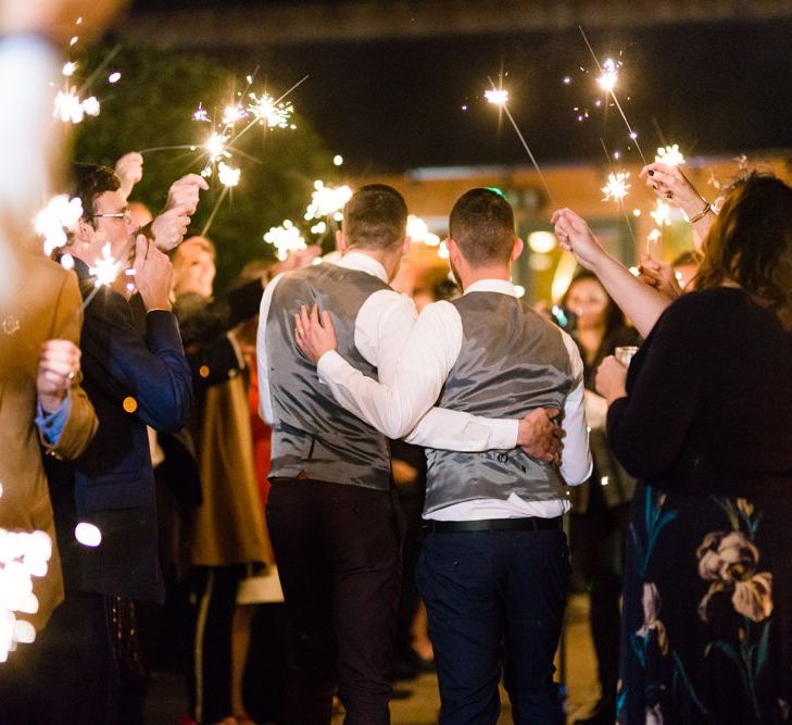 Sparkler Moment with Two Grooms in Burgundy and Navy Remus Uomo Suits