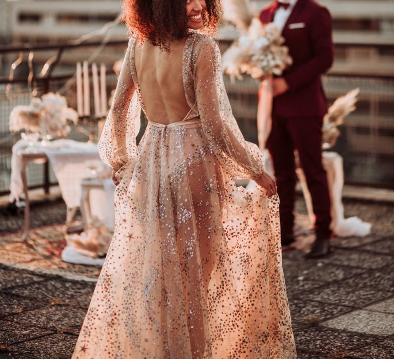 Bride in backless sparkle wedding dress with flowers in her hair