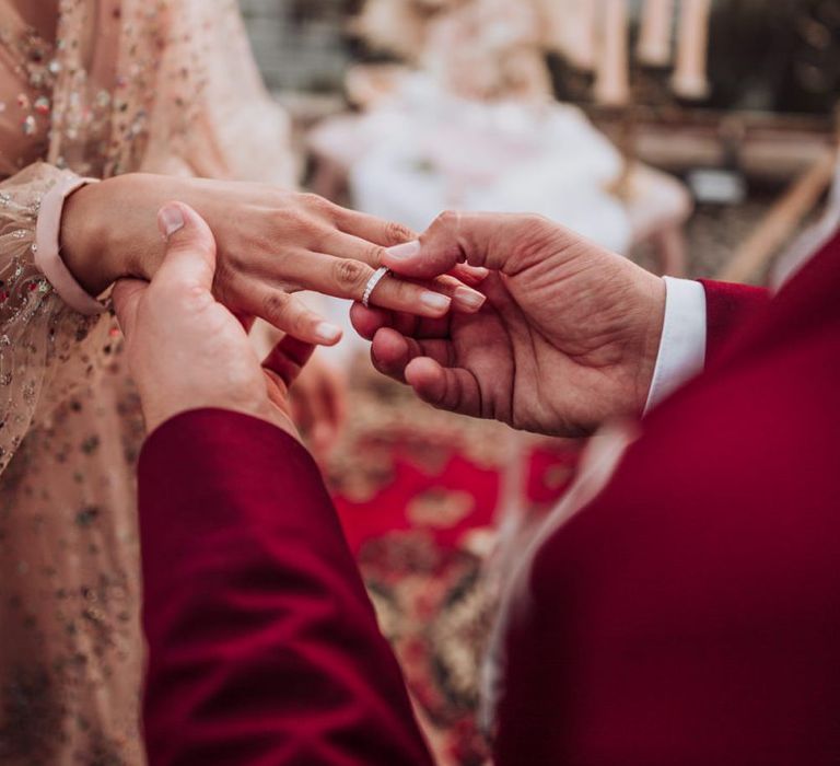 Groom putting on his brides engagement wedding ring