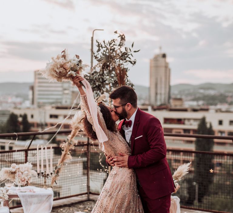 Boho bride and groom celebrating at intimate rooftop wedding