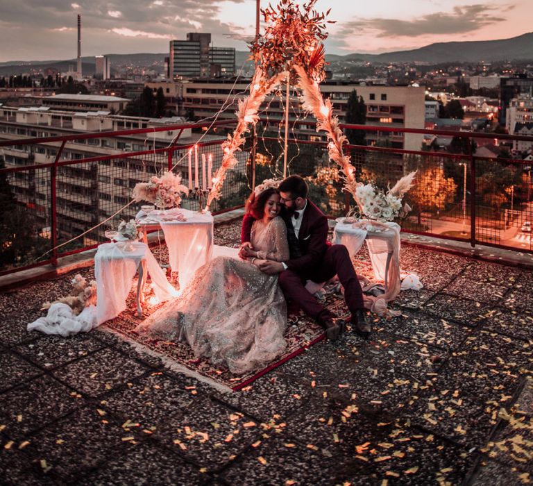 Intimate rooftop wedding celebration with fairy light covered tipi structure