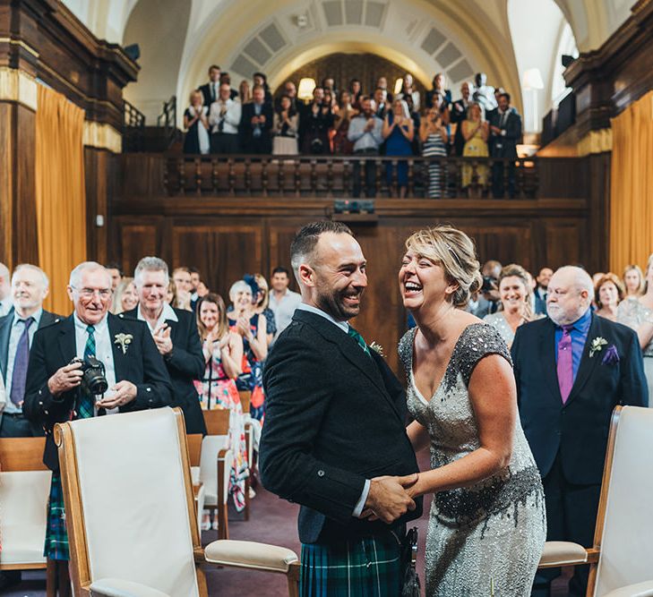 Bride in Embellished Shoulder Sequin Dress with Drop Waist by Eliza Jane Howell | Groom in Green and Blue Kilt | Wedding Ceremony at Stoke Newington Town Hall | Metallic Confetti Cannons and Paper Lanterns with Bride in Beaded Shoulder Eliza Jane Howell Dress | Miss Gen Photography