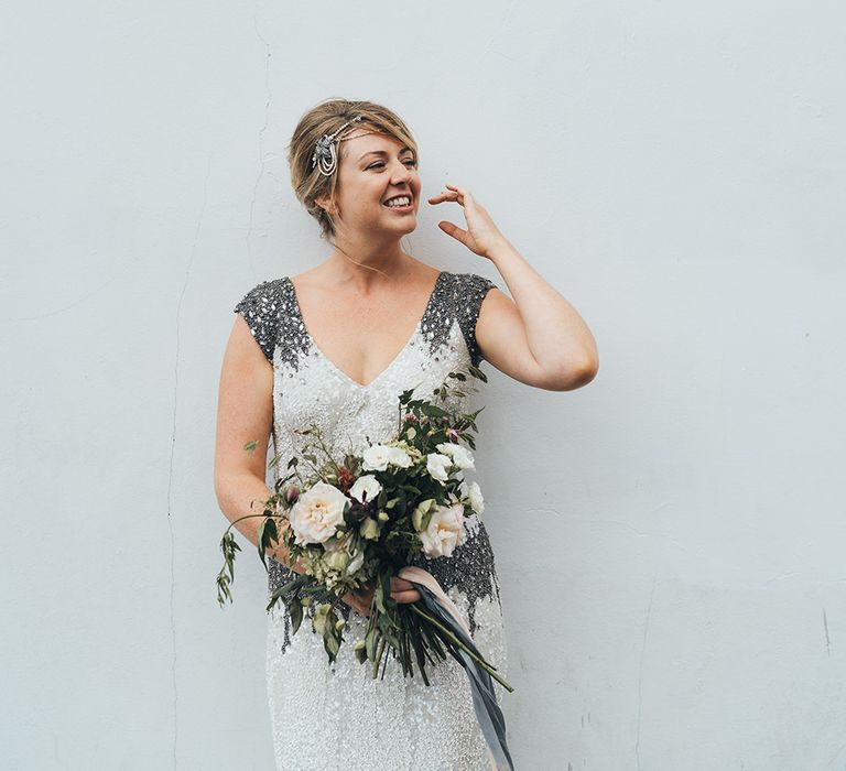 Bride in Embellished Shoulder Sequin Dress with Drop Waist by Eliza Jane Howell | 1920s Style Pearl Draping Headpiece | Bridal Bouquet with White Flowers, Foliage and Grey and Pink Trailing Ribbons | Metallic Confetti Cannons and Paper Lanterns with Bride in Beaded Shoulder Eliza Jane Howell Dress | Miss Gen Photography