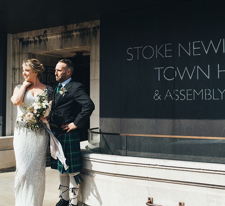 Bride in Embellished Shoulder Sequin Dress with Drop Waist by Eliza Jane Howell | 1920s Style Pearl Draping Headpiece | Bridal Bouquet with White Flowers, Foliage and Grey and Pink Trailing Ribbons | Groom in Green and Blue Tartan Kilt | Stoke Newington Town Hall Wedding Ceremony | Metallic Confetti Cannons and Paper Lanterns with Bride in Beaded Shoulder Eliza Jane Howell Dress | Miss Gen Photography