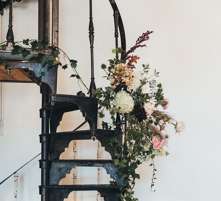 Floral Display Hanging from Winding Metallic Staircase | Wedding Reception at Clapton Country Club | Metallic Confetti Cannons and Paper Lanterns with Bride in Beaded Shoulder Eliza Jane Howell Dress | Miss Gen Photography