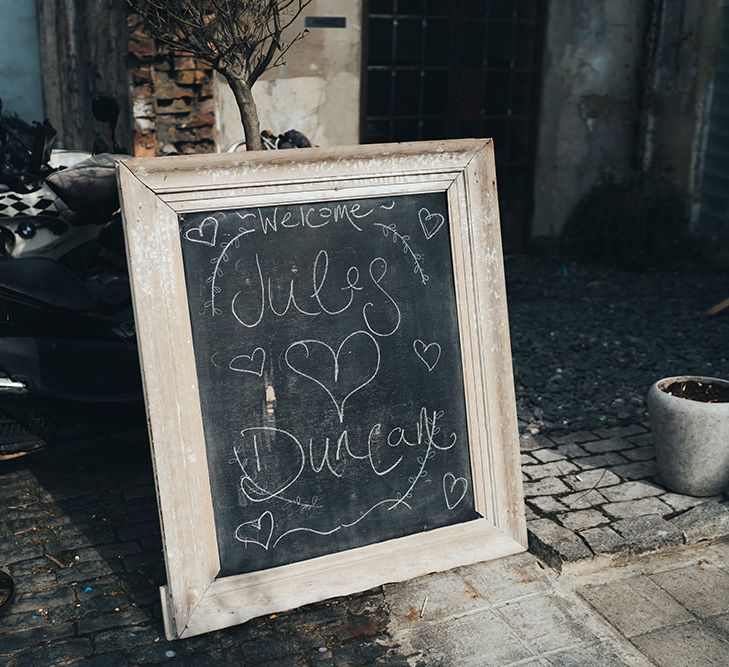 Chalkboard Welcome Sign | Wedding Reception at Clapton Country Club | Metallic Confetti Cannons and Paper Lanterns with Bride in Beaded Shoulder Eliza Jane Howell Dress | Miss Gen Photography