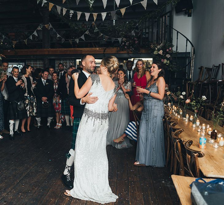 Bride in Embellished Shoulder Sequin Dress with Drop Waist by Eliza Jane Howell | Groom in Green and Blue Tartan Kilt | Wedding Bunting | Flowers Wrapped Around Pole | First Dance | Clapton Country Club Wedding Reception | Metallic Confetti Cannons and Paper Lanterns with Bride in Beaded Shoulder Eliza Jane Howell Dress | Miss Gen Photography