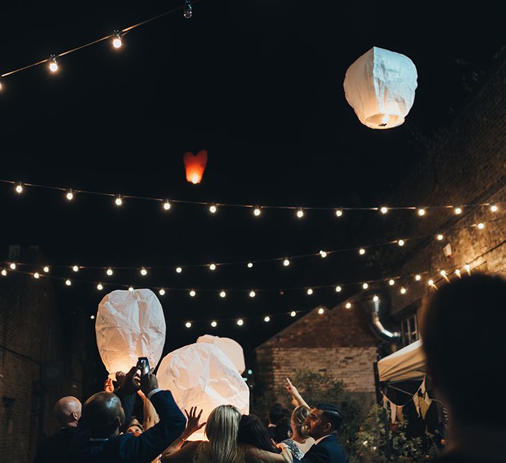 Wedding Guests Letting Off Paper Lanterns | Festoon Lights | Clapton Country Club Wedding Reception | Metallic Confetti Cannons and Paper Lanterns with Bride in Beaded Shoulder Eliza Jane Howell Dress | Miss Gen Photography