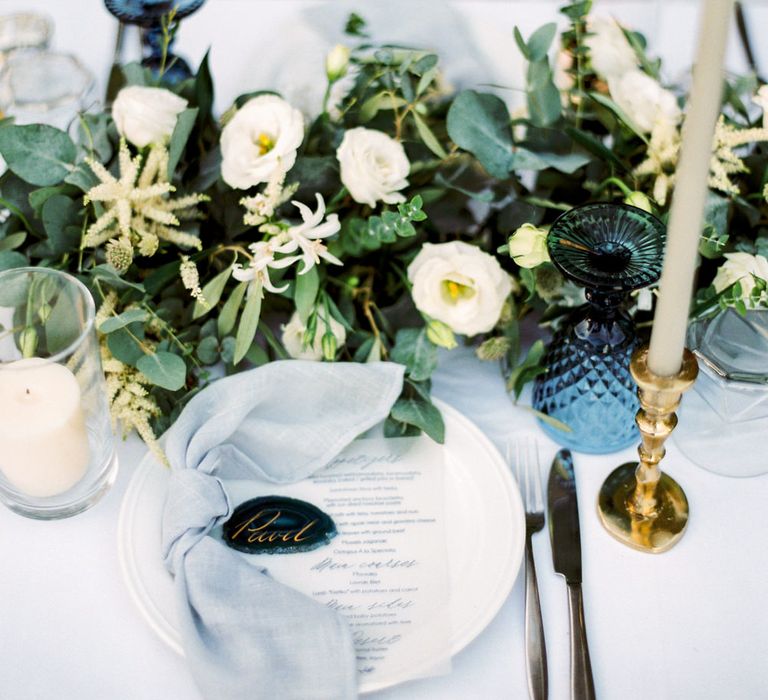 Elegant Place Setting with Coloured Goblet, Floral Table Runner, Taper Candles &amp; Geode Name Place | Pastel Blue &amp; Green, Romantic, Destination Wedding at Corfu Luxury Villas, Planned by Rosmarin Weddings &amp; Events | Mikhail Balygin Fine Art Wedding Photographer