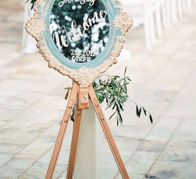 Mirror Welcome Sign on Easel  | Pastel Blue &amp; Green, Romantic, Destination Wedding at Corfu Luxury Villas, Planned by Rosmarin Weddings &amp; Events | Mikhail Balygin Fine Art Wedding Photographer