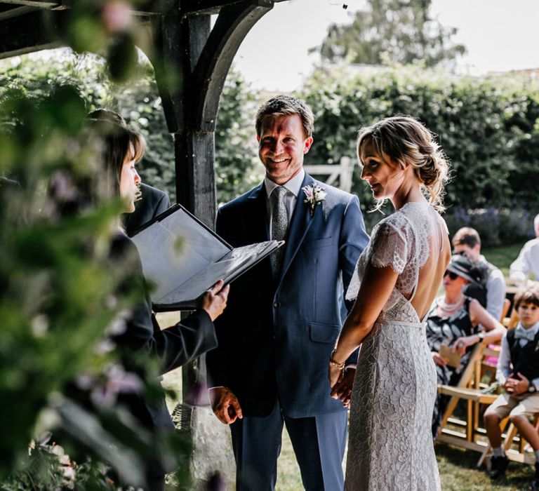 Outdoor Wedding Ceremony with Bride in Lace Made with Love Wedding Dress and Groom in Navy Suit