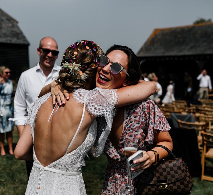 Bride in Lace Made with Love Wedding Dress Hugging Wedding Guest