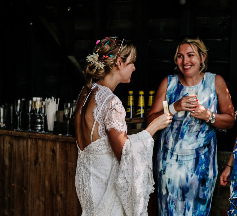 Bride in Lace Made with Love Wedding Dress Talking to Wedding Guests