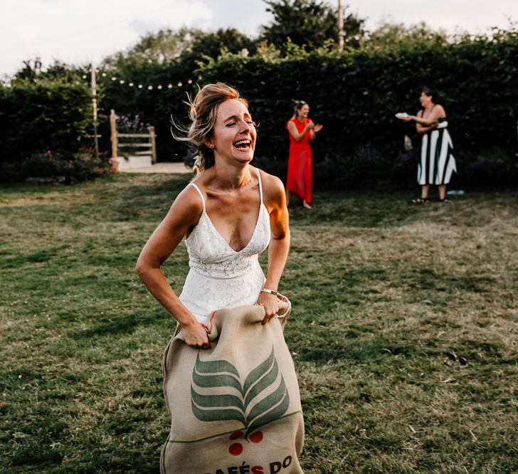 Bride in Lace Made with Love Wedding Dress Doing a Sack Race