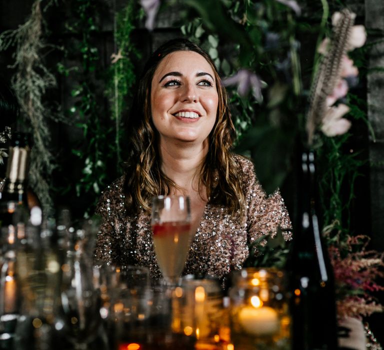 Bridesmaid in Maya Dress Sitting at the Top Table with Foliage Backdrop