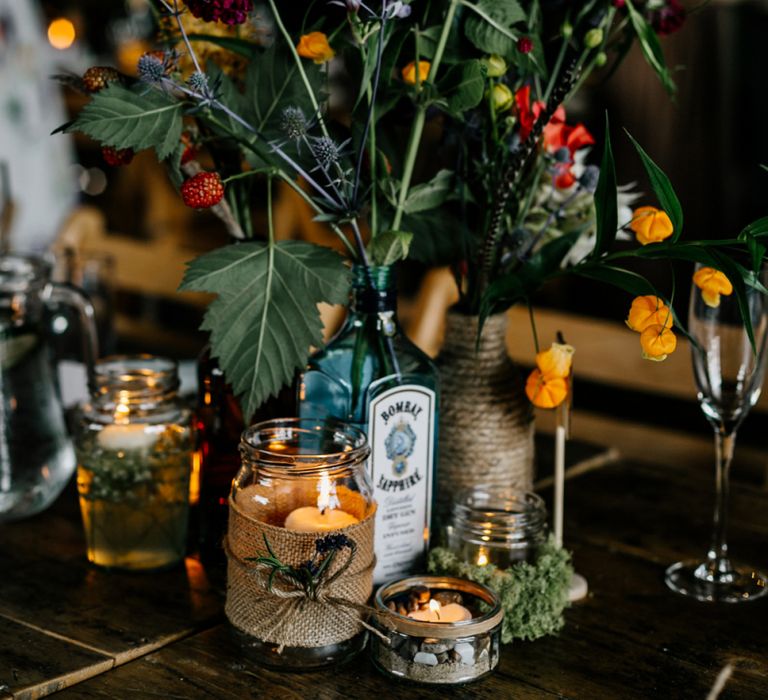 Wild Flower Stems in Gin Bottle as Table Centrepiece