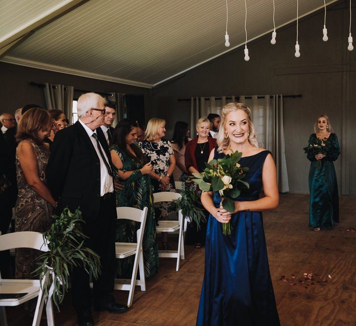 Bridesmaid Walks Down The Aisle For Wedding With Polaroid Guest Book