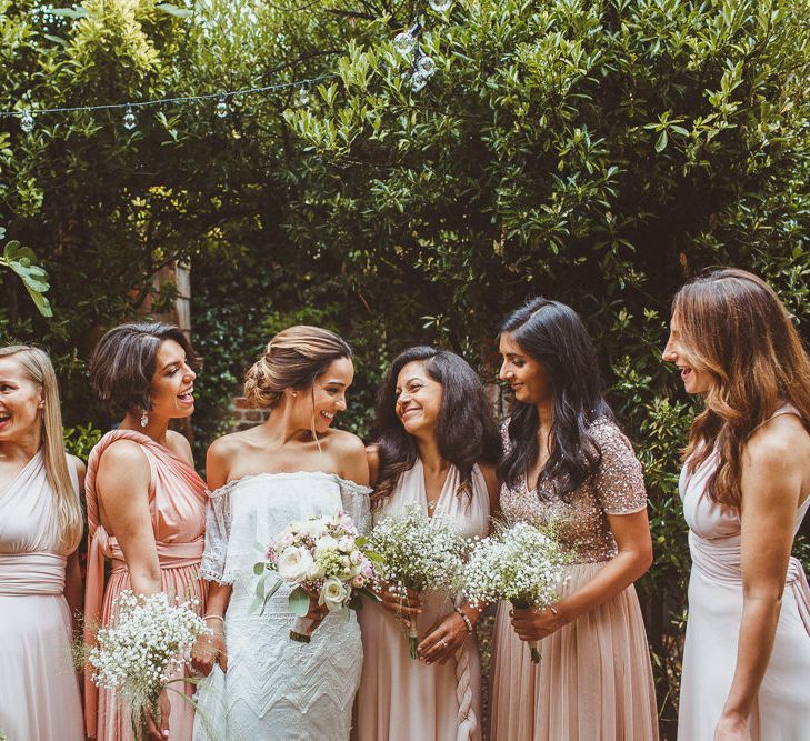 Bridal Party Looking at Gypsophila Bouquets with Bride in Grace Loves Lace Wedding Dress