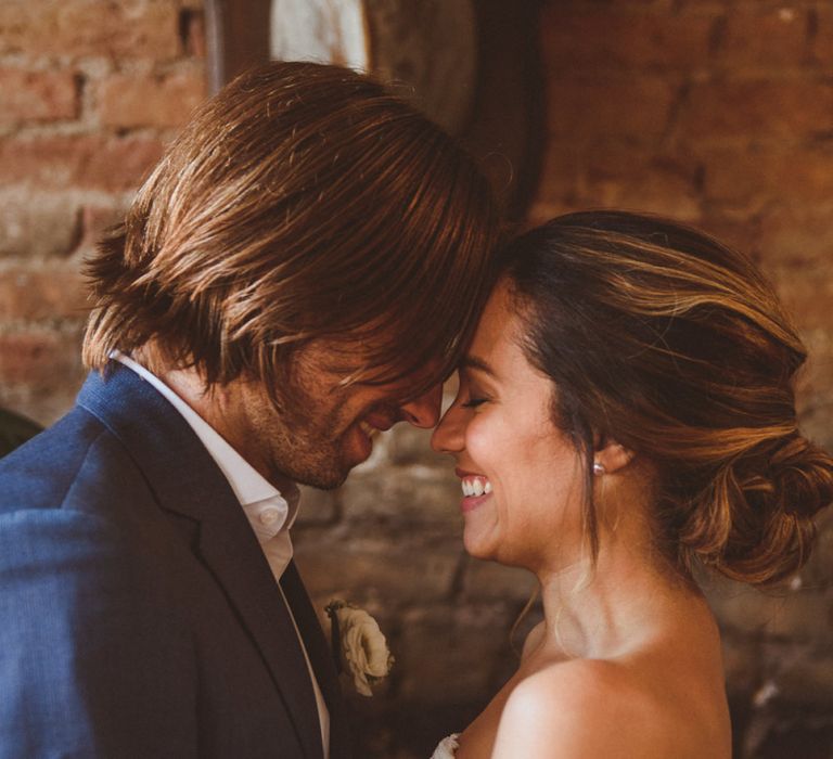 Bride in Grace Loves Lace Dress and Groom in Blue Blazer Embracing