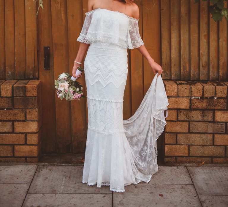 Beautiful Bride in Off The Shoulder 'Emanuela' Grace Loves Lace Wedding Dress Holding Her Train &amp; Bouquet