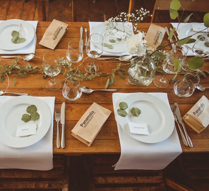 Wooden Table with White Tableware and Foliage Decor