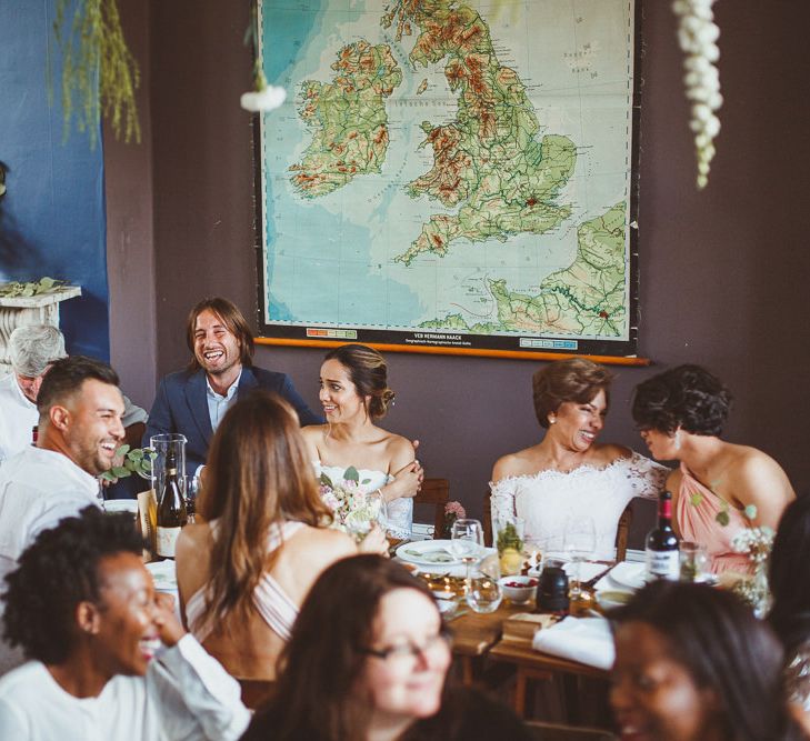 Bride and Groom Sitting at the Top Table with Giant Map Backdrop