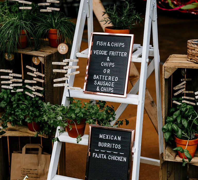 Rustic Table Plan For Wedding With Ladders // Bride In Floral Dress By Stephanie Allin Festival Wedding With Food Trucks &amp; Outdoor Ceremony With Geo Dome Tent Baya Hire Epic Love Story Photography