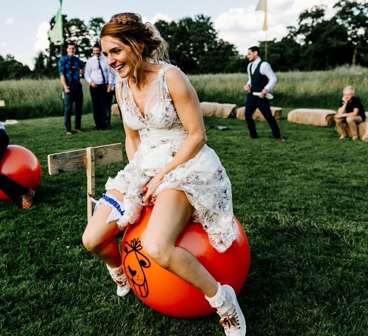 Space Hopper Race Wedding Games // Bride In Floral Dress By Stephanie Allin Festival Wedding With Food Trucks &amp; Outdoor Ceremony With Geo Dome Tent Baya Hire Epic Love Story Photography