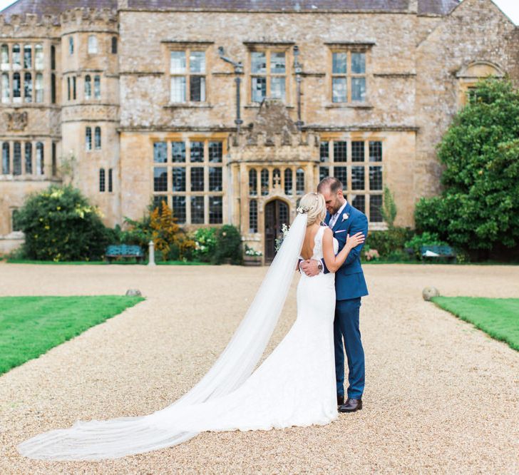 Bride in St Patrick La Sposa Wedding Dress and Groom in Blue Reiss Suit in Front of Their Wedding Venue