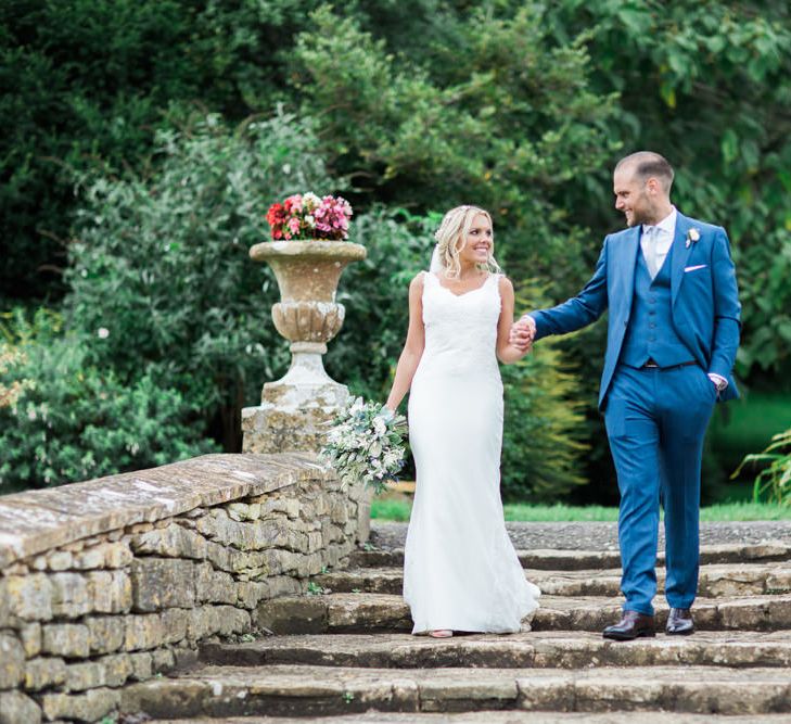 Bride in St Patrick La Sposa Wedding Dress and Groom in Blue Reiss Suit Walking Down Steps