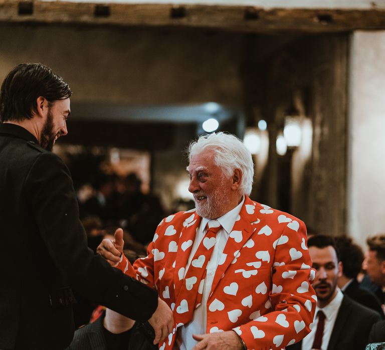 Guest wearing bright red suit at winter wedding in Northumberland