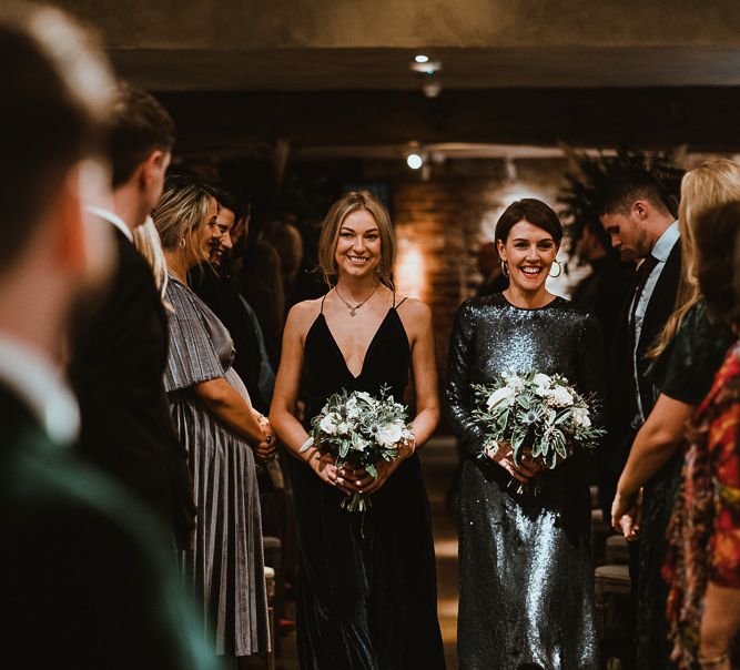 Bridesmaids wearing black dresses and white floral bouquets