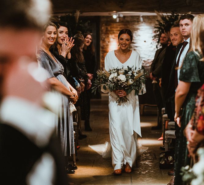 Bride wearing elegant three piece bridal dress and white floral bouquet