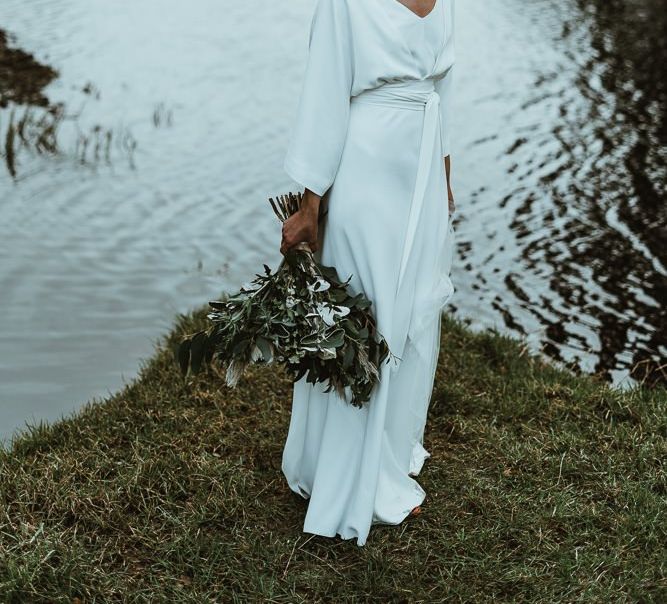 Bride wearing elegant three piece Charlie Brear dress with long sleeve top and detachable belt