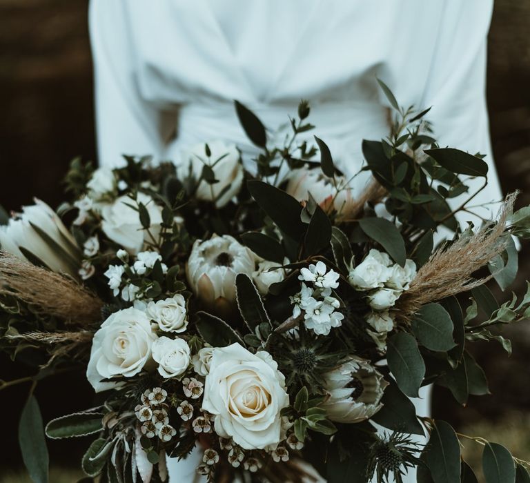 Bouquet details with white roses and foliage at winter wedding