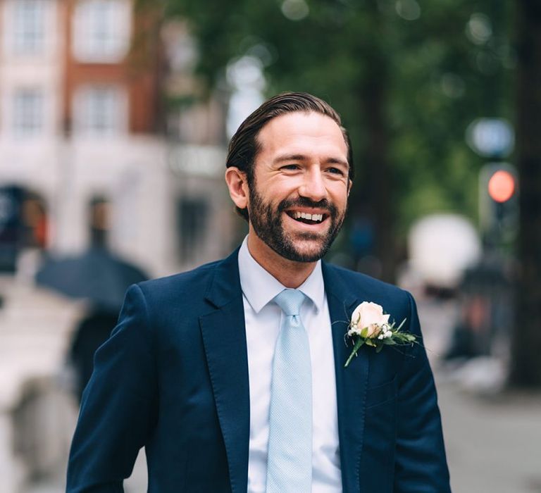 Groom in navy suit and baby blue bow tie