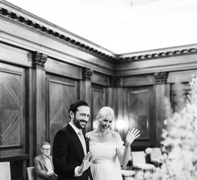 Bride and groom waving to guests via video conferencing