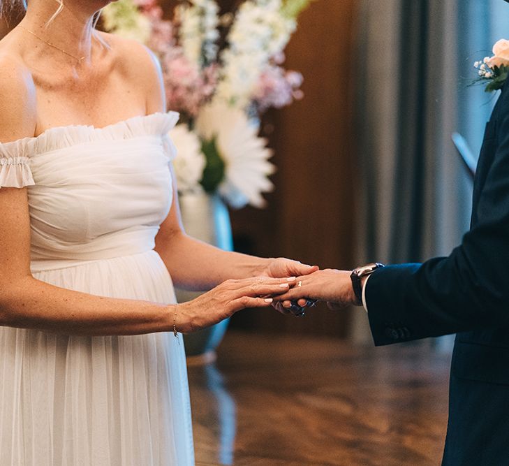 Bride and groom exchanging rings at intimate London wedding