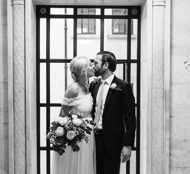 Portrait of bride in maternity wedding dress and groom in lounge suit